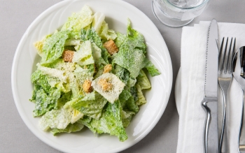 Romaine lettuce with Caesar dressing, topped with parmesan cheese and croutons